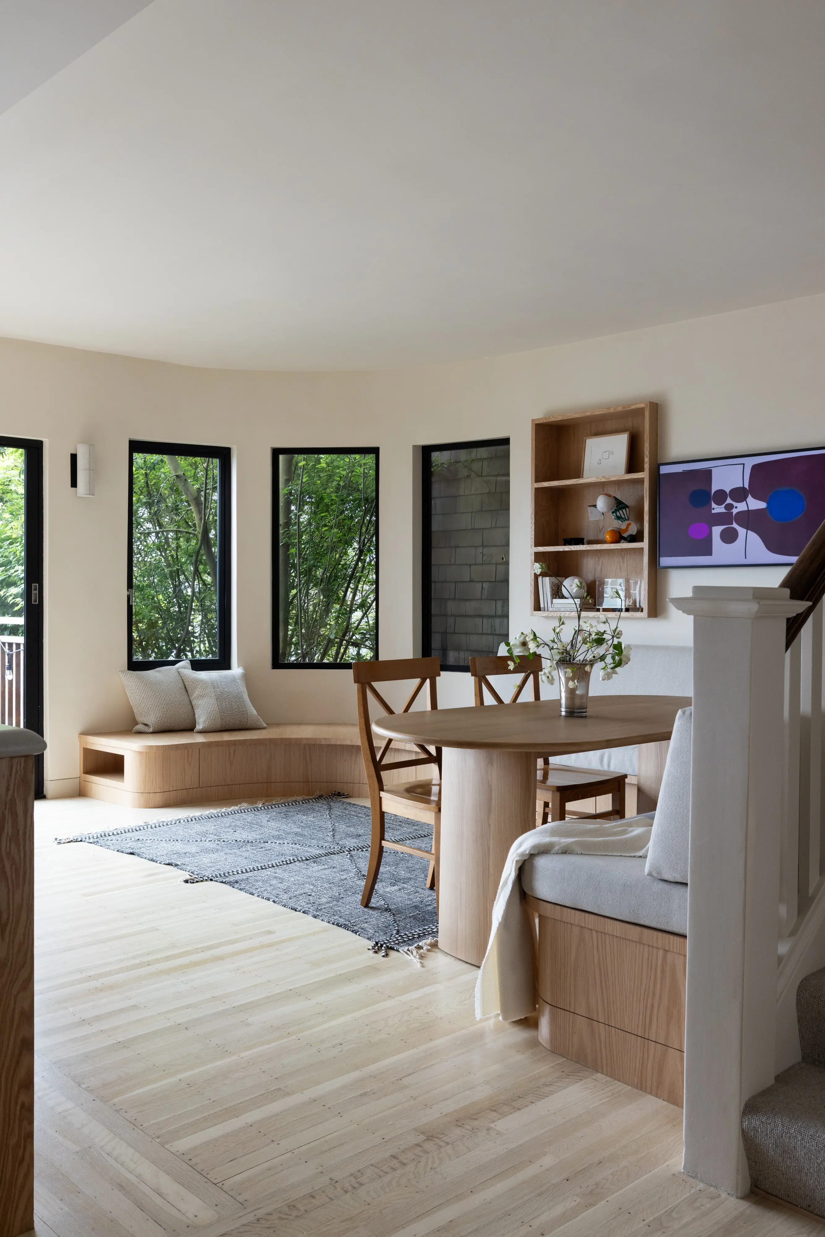 Parnassus Heights sunlit dining nook, a curved built-in red oak bench, an oval pedestal table, and cross-back chairs