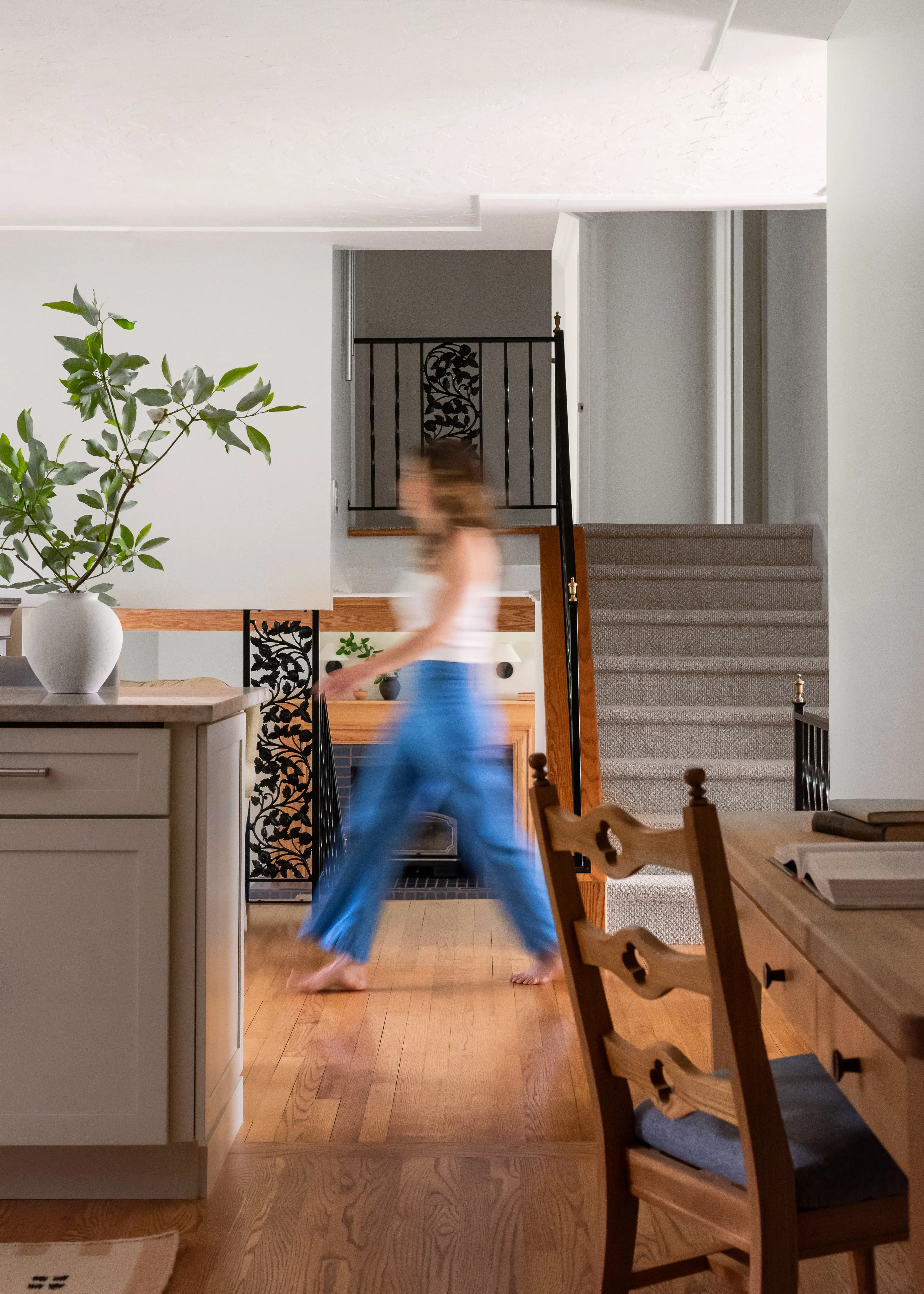 Timeless neutral kitchen in an Oberlin, Ohio home renovation by Studio VAE, with a view through to the sun room and stair